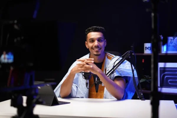 A confident podcaster speaking into a microphone in a modern studio setting.