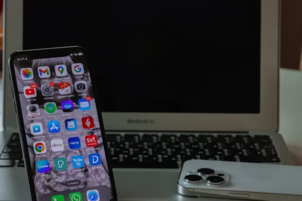 Close-up of a smartphone and laptop on a desk, displaying productivity and connectivity.