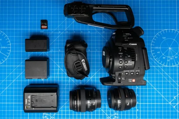 Flat lay of Canon cinema camera and gear on blueprint for filmmaking.